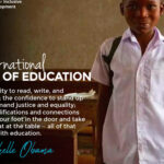 Poster for International Day of Education showing a school-aged child wearing a white school uniform and backpack standing in a classroom. The poster features a quote by Michelle Obama stating that education provides the ability to read, write, analyse, build confidence, pursue justice and equality, and gain opportunities, concluding that all of these begin with education.
