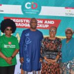 Four participants stand together for a group photograph at a Centre for Inclusive Development event. Behind them is a branded backdrop featuring the Centre for Inclusive Development logo, with support from the Ford Foundation and partnership with the Yar'Adua Foundation. One participant wears a green T-shirt promoting the Special Seats Bill for Women, while the others wear professional and traditional attire.