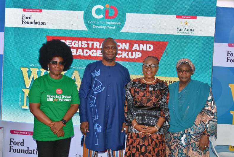 Four participants stand together for a group photograph at a Centre for Inclusive Development event. Behind them is a branded backdrop featuring the Centre for Inclusive Development logo, with support from the Ford Foundation and partnership with the Yar'Adua Foundation. One participant wears a green T-shirt promoting the Special Seats Bill for Women, while the others wear professional and traditional attire.